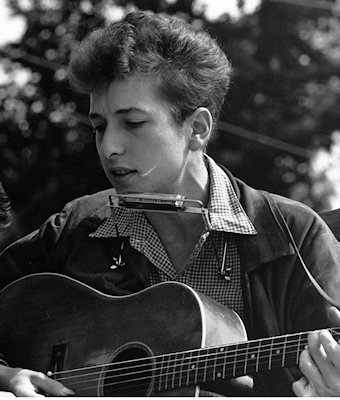 A young Bob Dylan singing protest songs at a rally in the US. 